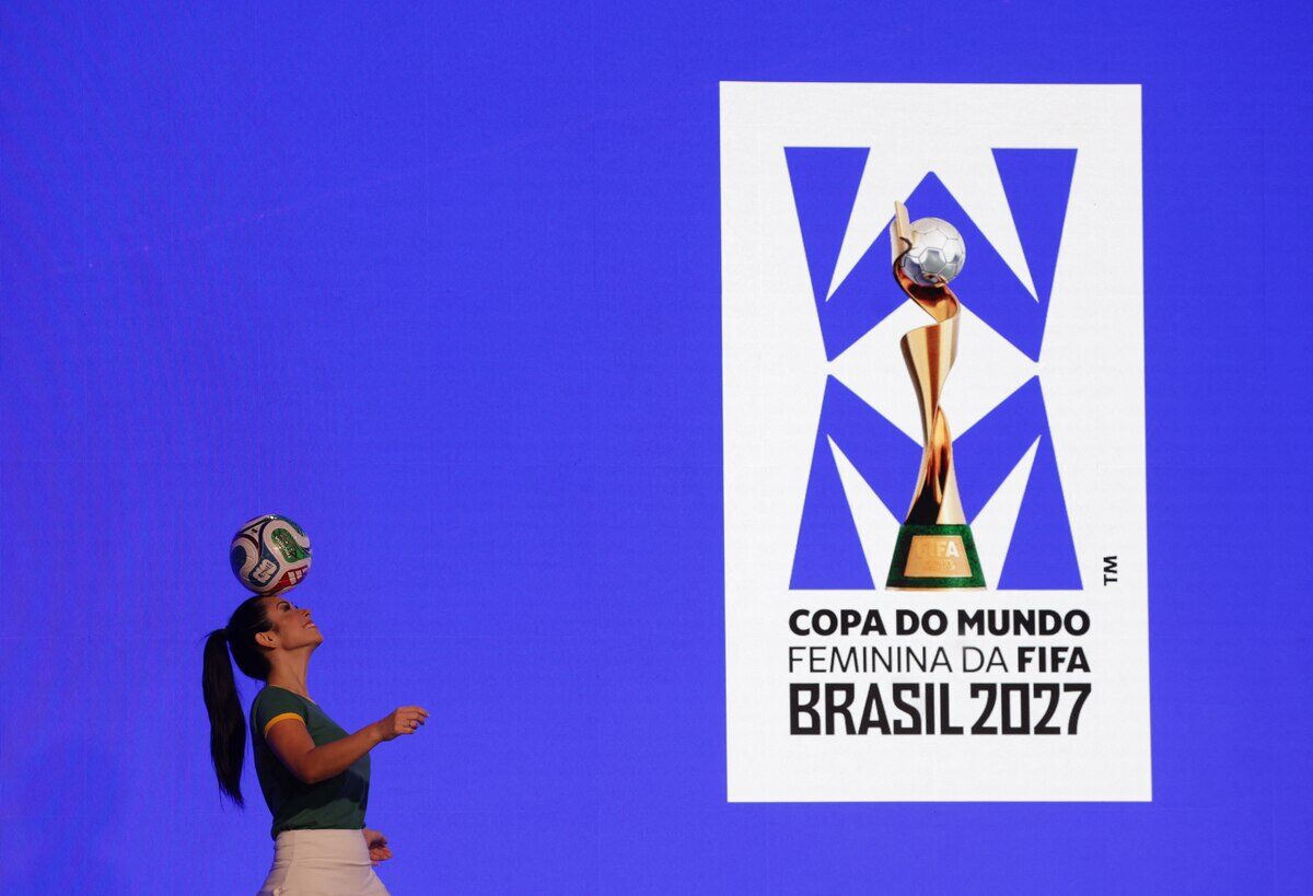 Mujer equilibrando un balón de fútbol frente al logo de la Copa del Mundo Femenina de la FIFA Brasil 2027