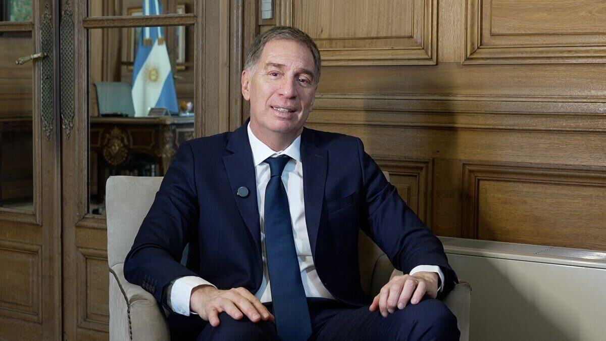 Darío Genua sentado en un sofá en un entorno oficial