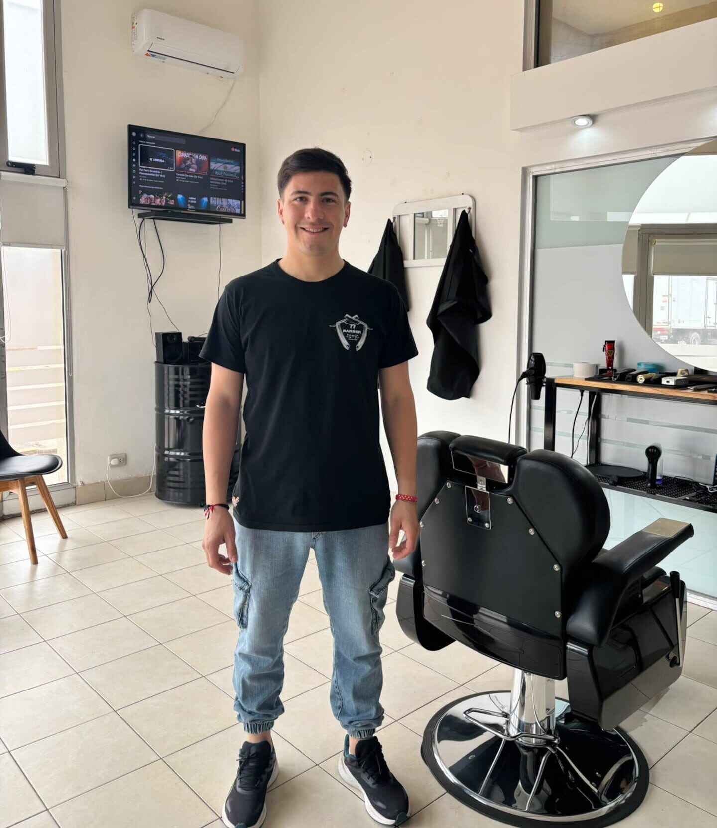 Gabriel Vera, el barbero de Scaloni, posando en su barbería