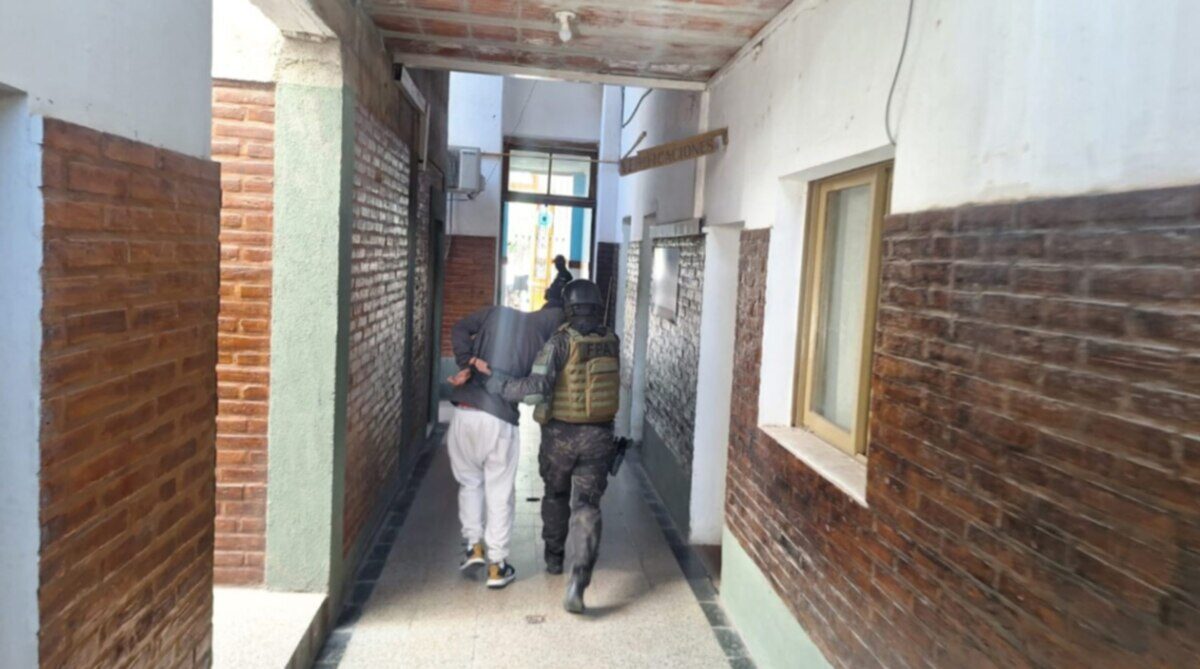 Agente de la Fuerza Policial Antinarcotráfico detiene a un sospechoso en un pasillo de Villa Dolores