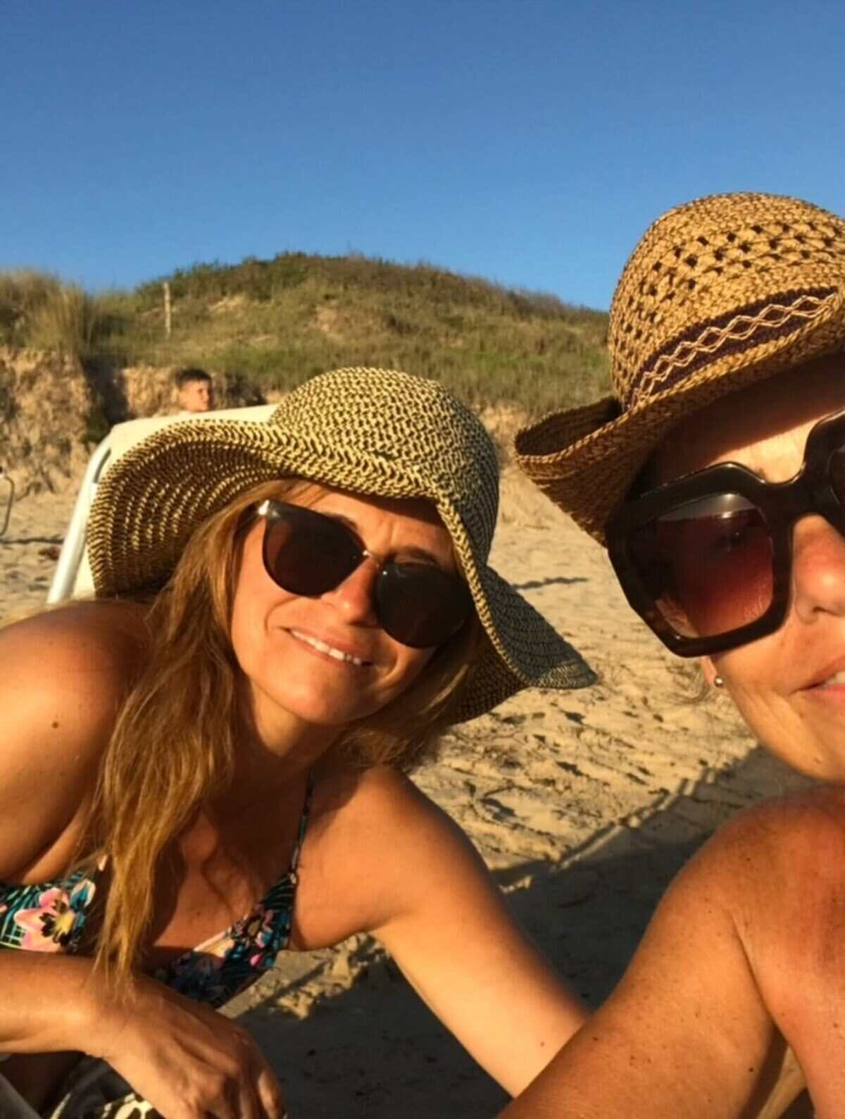 Majo Riera y su amiga Sandra en la playa, usando sombreros y gafas de sol