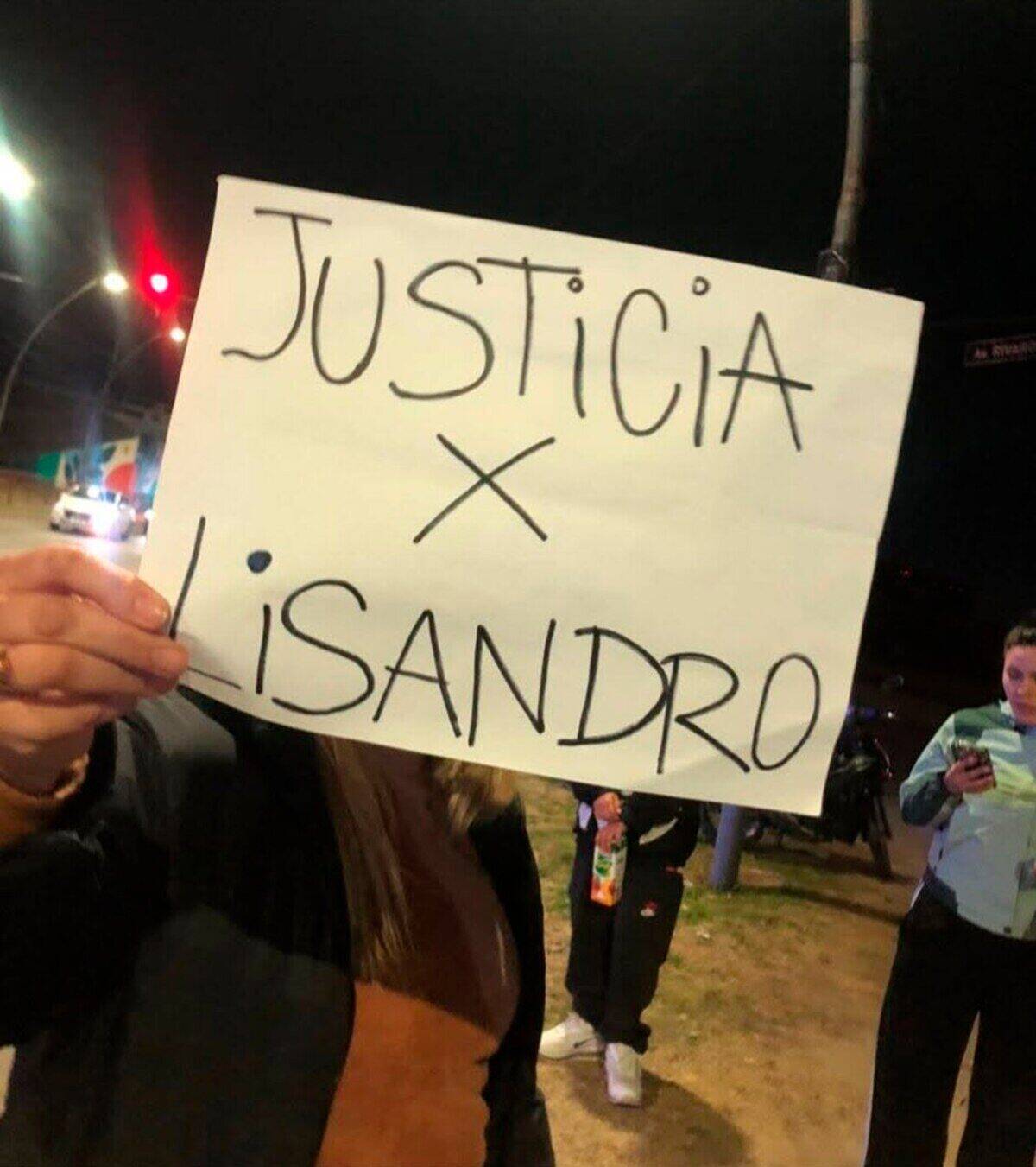 Mujer sostiene un cartel que dice 'Justicia x Lisandro' en una manifestación