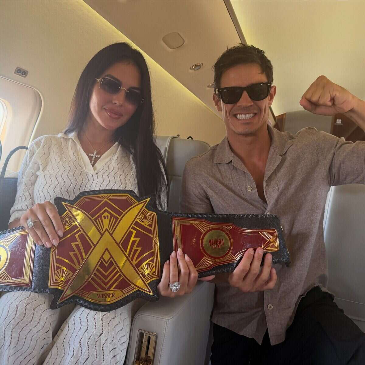 Edu Aguirre y Georgina Rodríguez celebran con el cinturón de campeón en un avión privado