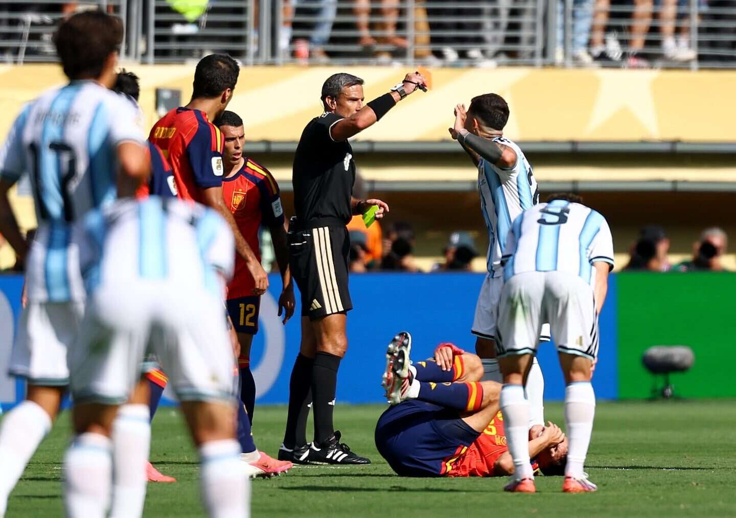 El árbitro Slavko Vincic muestra una tarjeta amarilla durante un partido de fútbol entre Argentina y España
