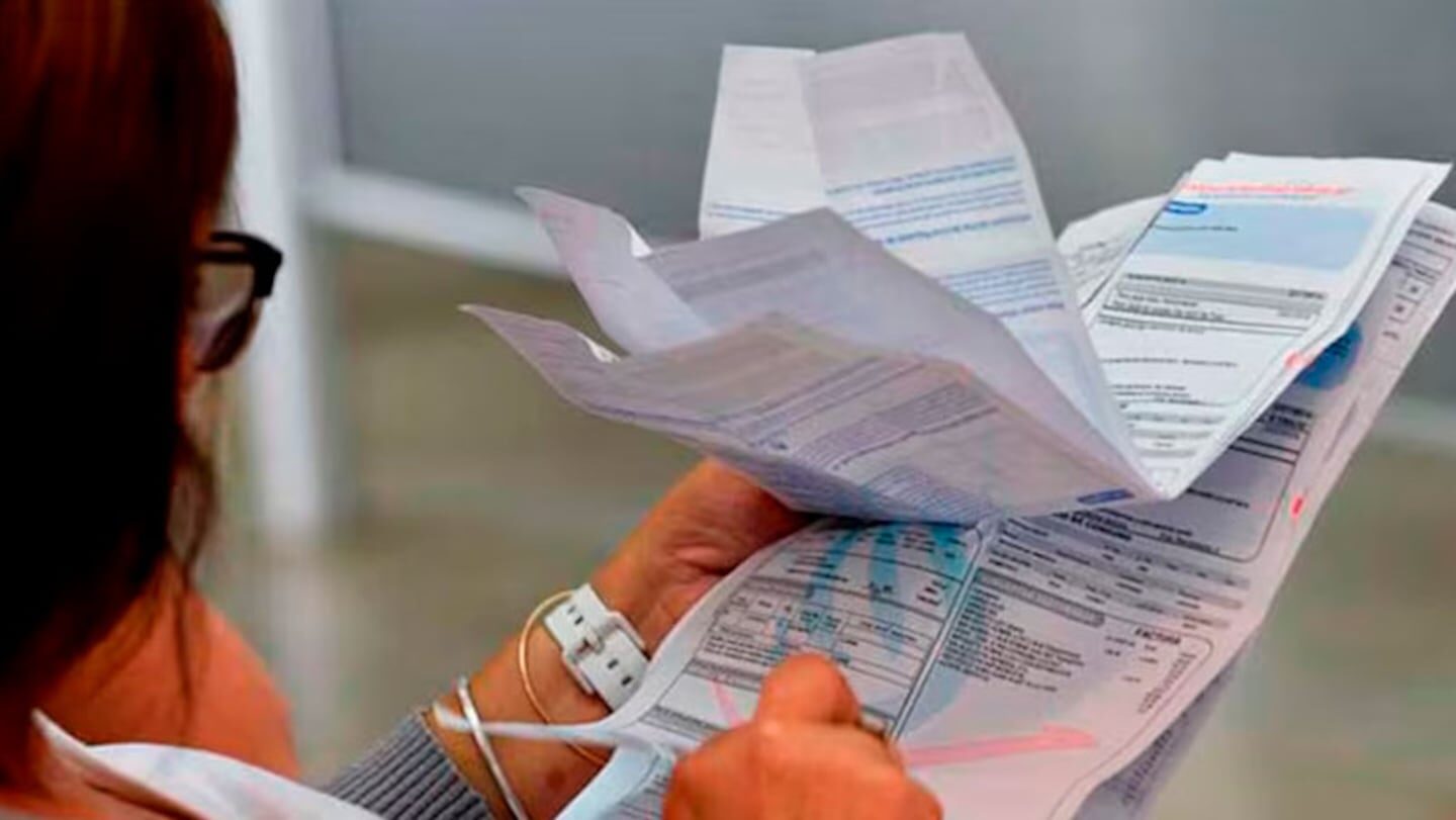 Mujer revisando facturas y documentos relacionados con gastos de vivienda en Argentina