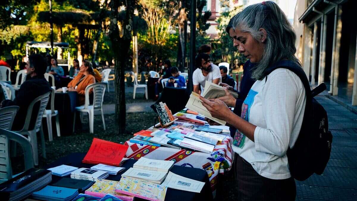 Mujer revisando libros en una mesa durante el Festival Internacional de Literatura Tucumán