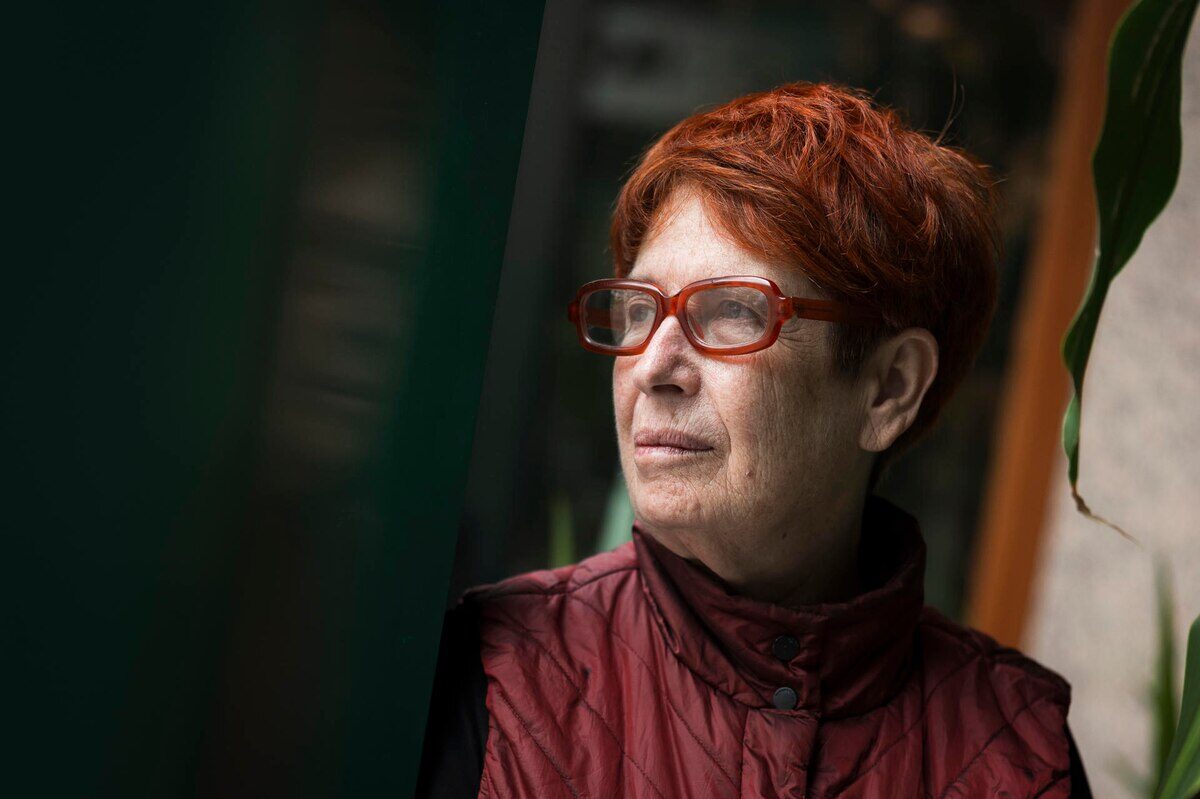 Retrato de una mujer con cabello rojo y gafas, mirando hacia un lado