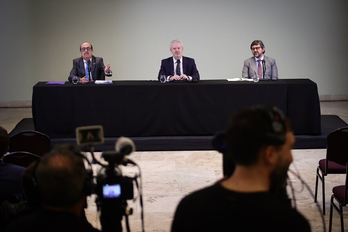 Tres funcionarios discuten en una mesa durante una conferencia de prensa en la Casa Rosada