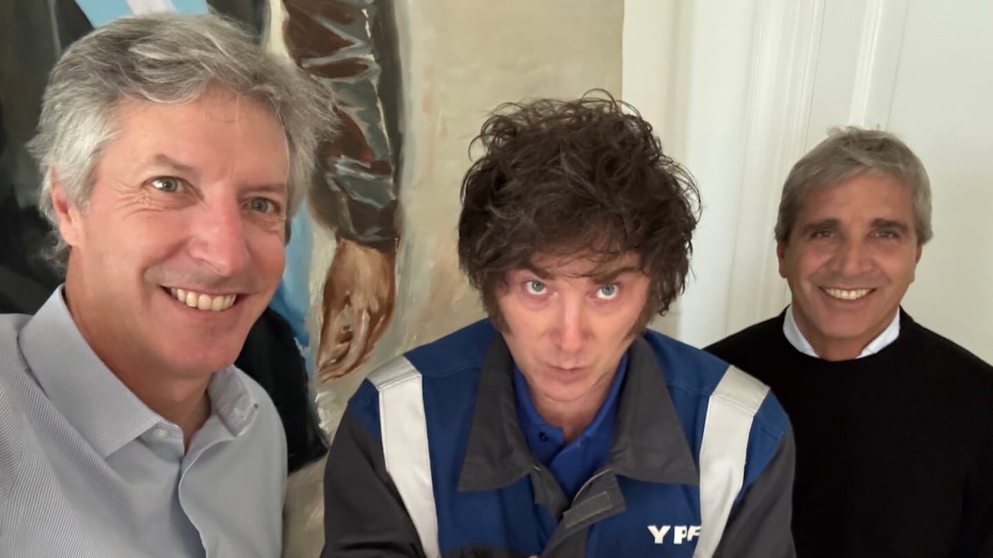 Tres hombres posando en un entorno interior, uno de ellos con un overol de YPF