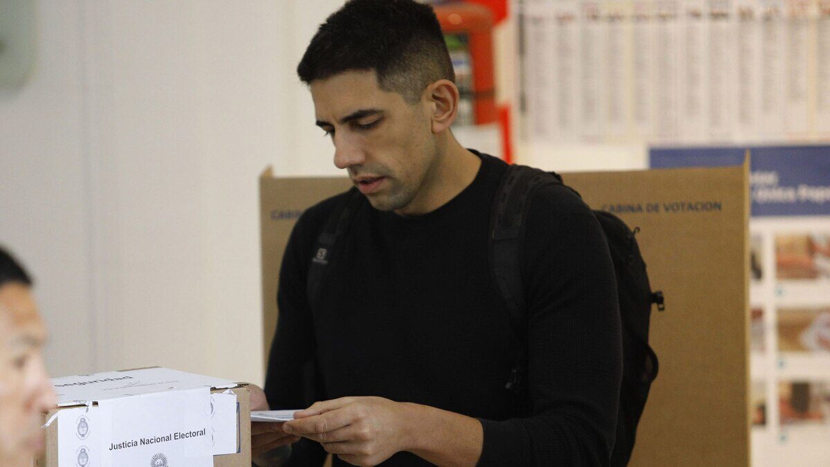 Hombre depositando un voto en una urna electoral durante las elecciones