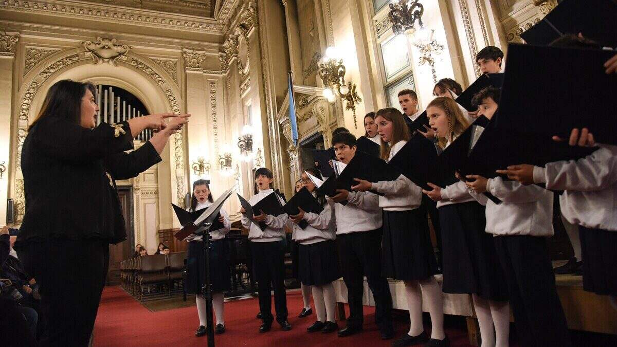 Directora del Coro Nacional de Niños dirigiendo a los cantantes en un evento