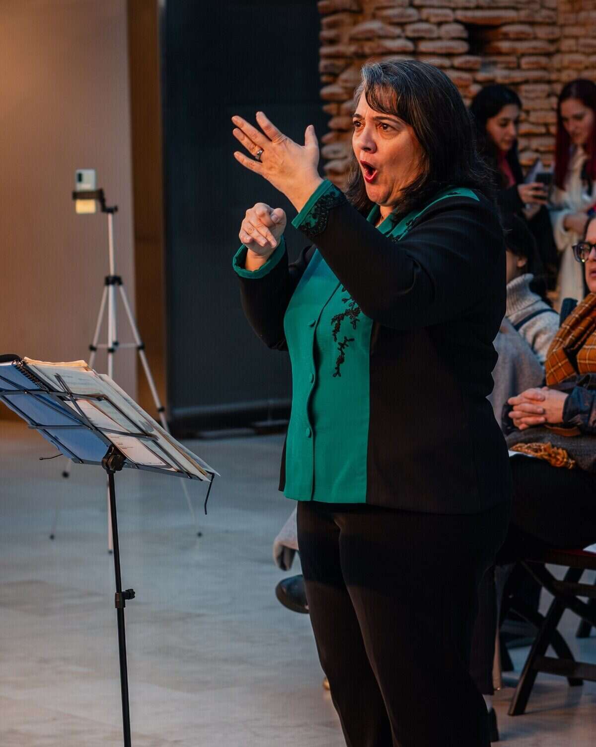 Directora del Coro Nacional de Niños dirigiendo una presentación musical