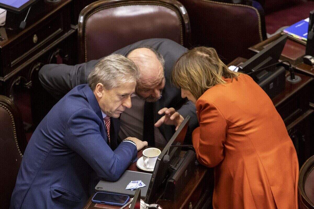 Tres legisladores discuten en el Senado durante el debate sobre la Ley de Tierras