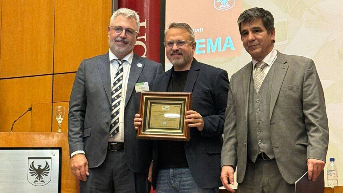 Tres hombres posando con un reconocimiento en un evento relacionado con el Hotel Provincial Plaza de Salta