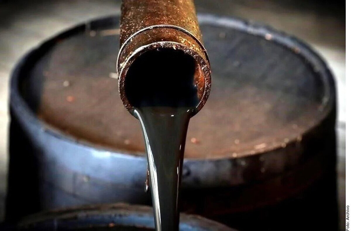 Tubería de petróleo crudo vertiendo en un barril