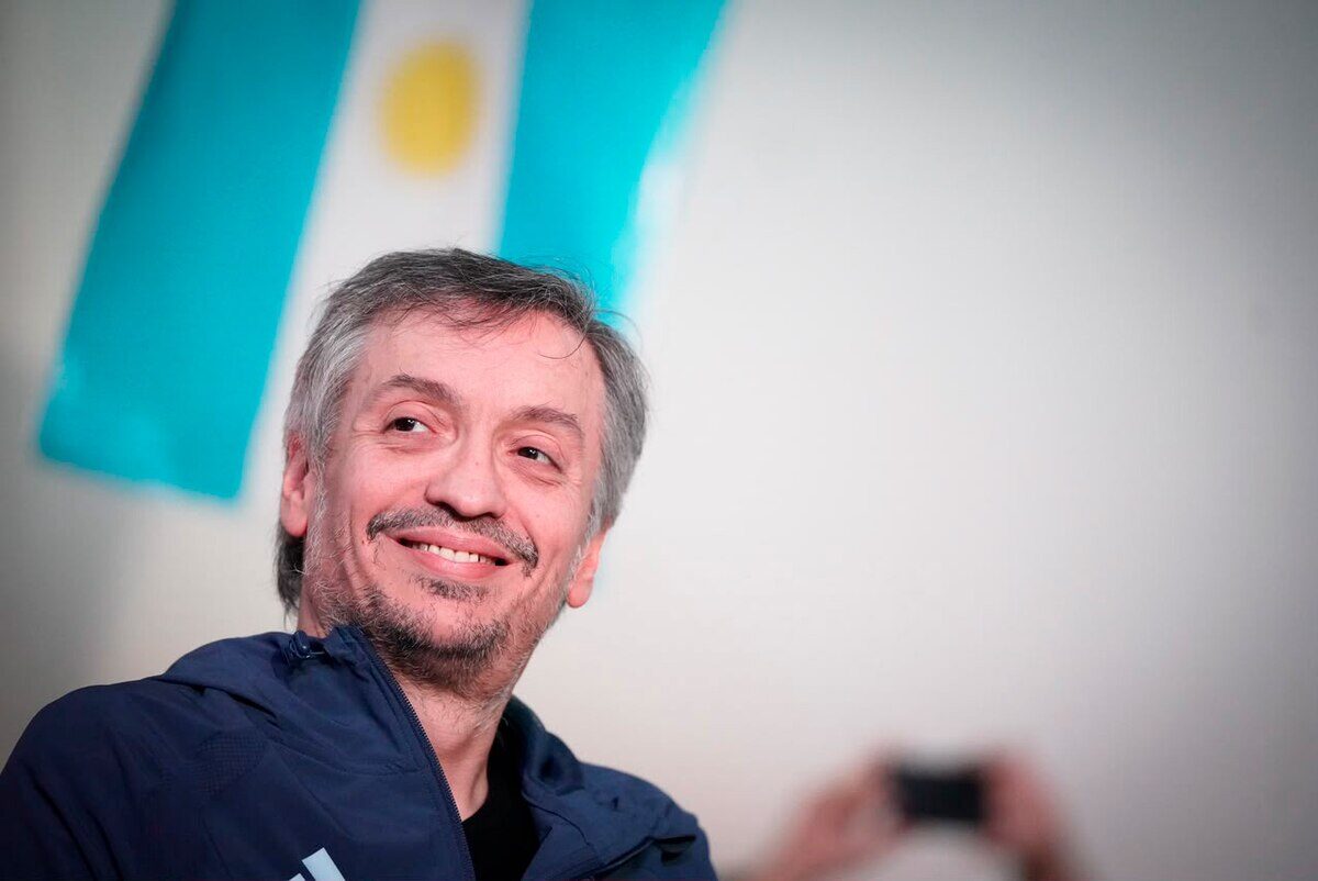 Hombre sonriendo con una bandera argentina de fondo