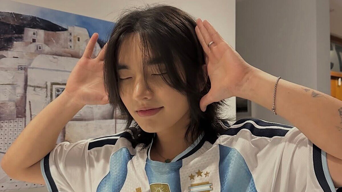 Jin Min Lee con camiseta argentina, posando con las manos en la cabeza