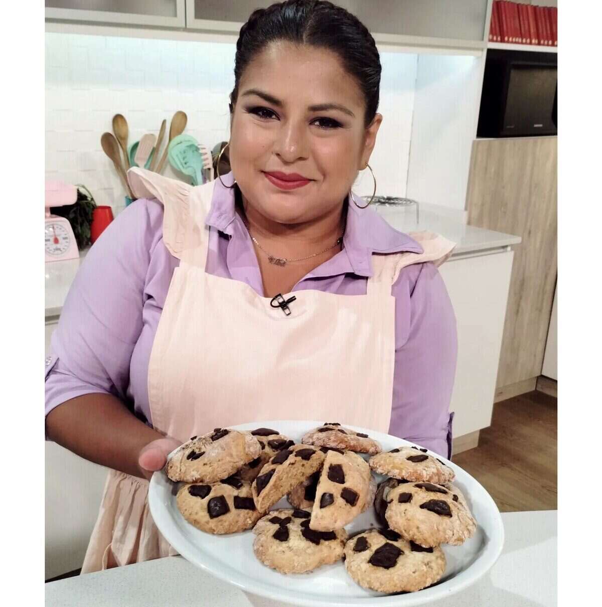 Elba Rodríguez sosteniendo una bandeja de galletas recién horneadas en la cocina