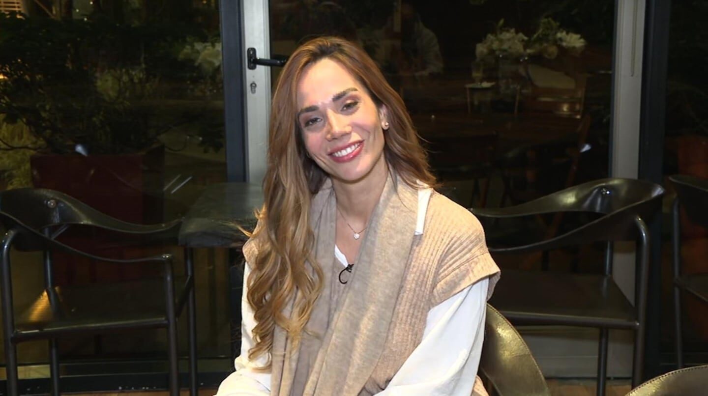 Mujer sonriendo sentada en un ambiente acogedor