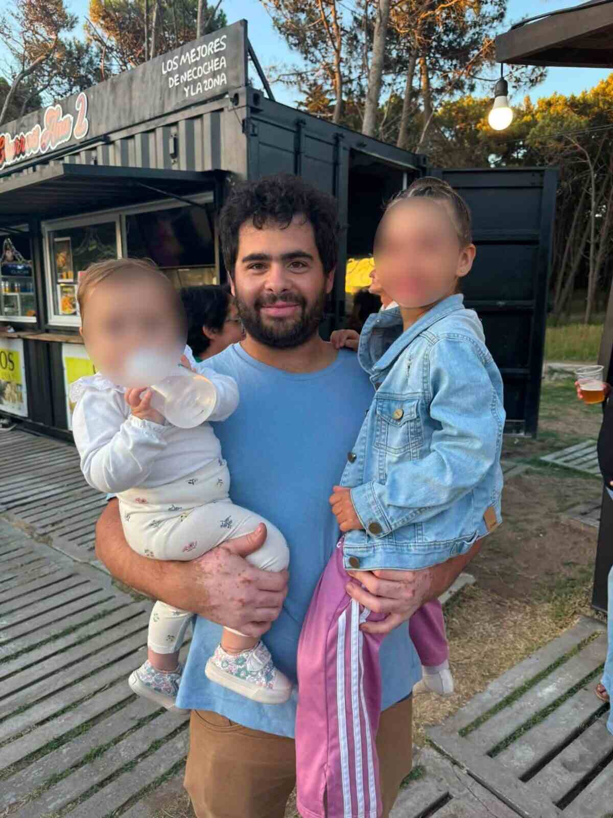 Santiago Duca sosteniendo a dos niños en un entorno familiar en Necochea