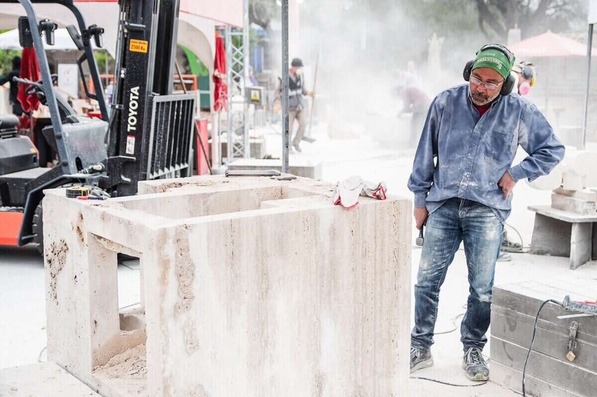 Escultor trabajando en una obra de piedra en la Bienal de Esculturas del Chaco
