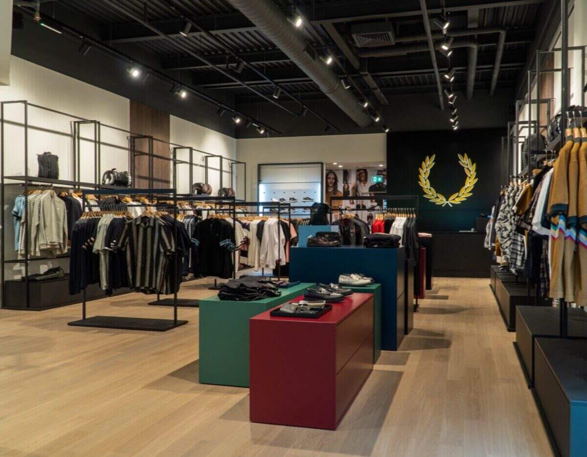 Interior de la tienda Fred Perry en Buenos Aires con ropa expuesta en estantes y mesas