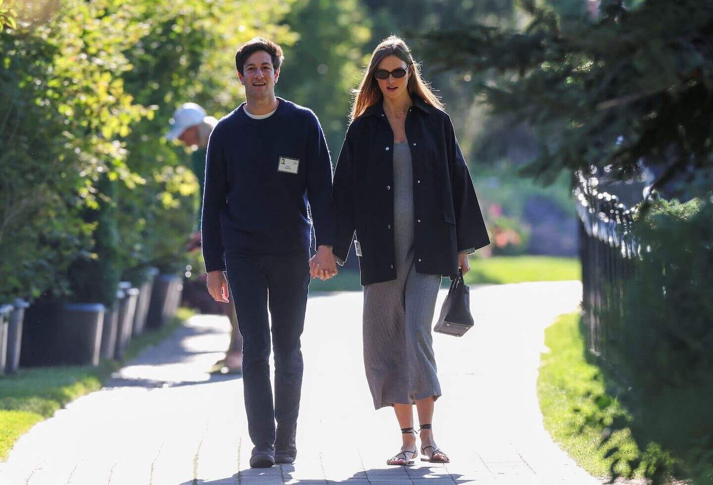 Joshua Kushner caminando de la mano con una mujer en un entorno natural