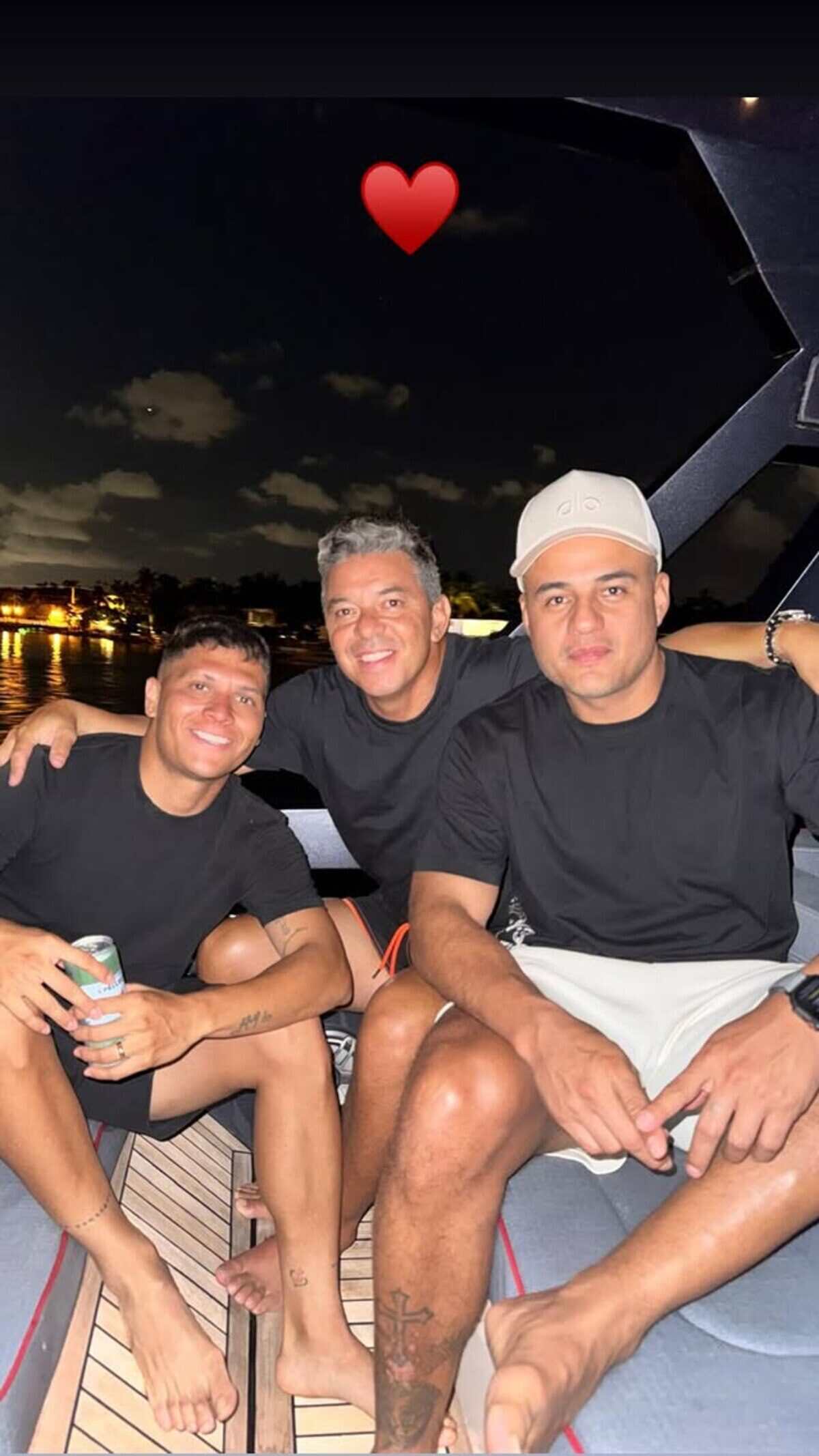 Juanfer Quintero y Marcelo Gallardo posando en un yate junto a un amigo en la noche