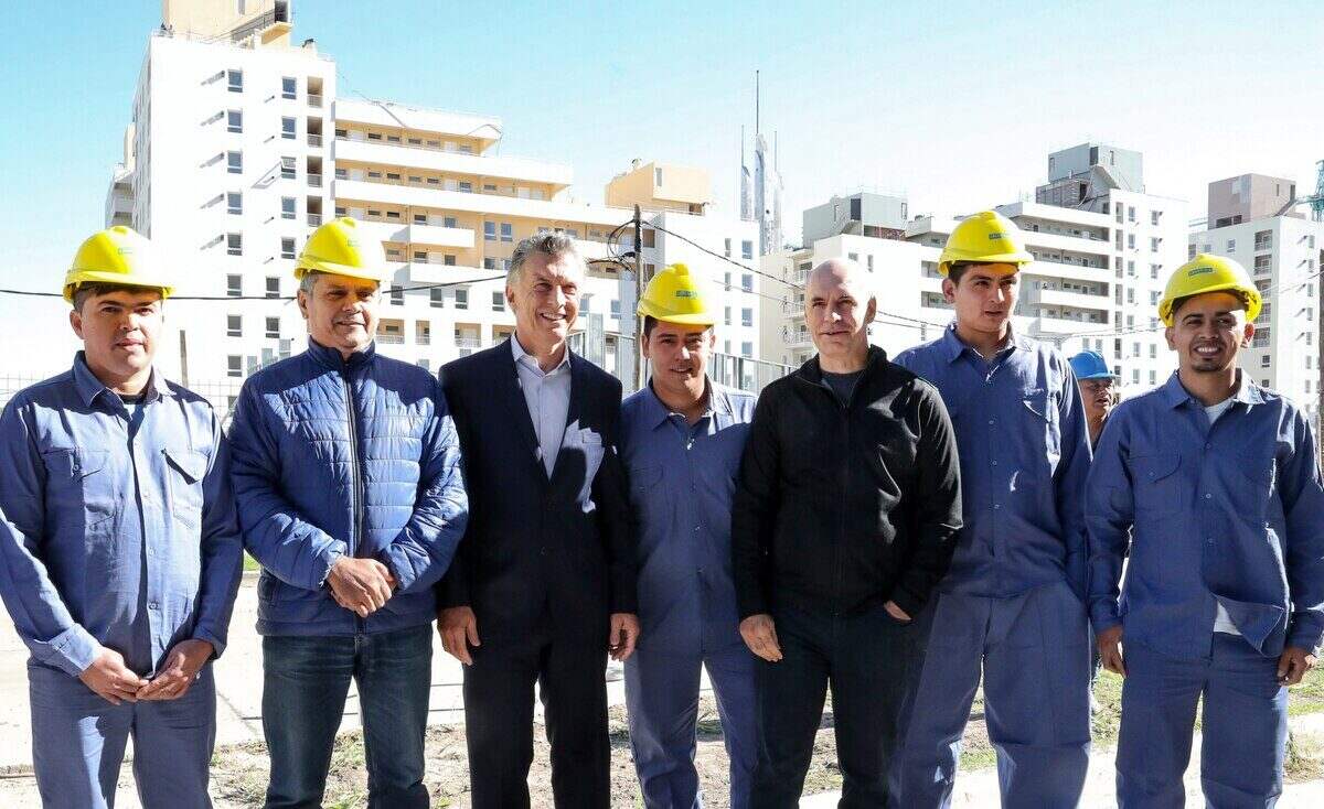 Funcionarios y trabajadores de la construcción en un sitio de obra del Plan Nacional de Vivienda