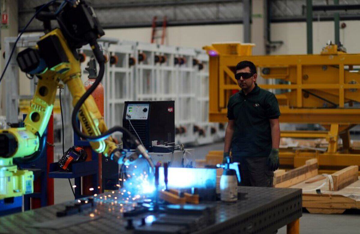 Un trabajador observa un robot industrial en una fábrica de Argentina
