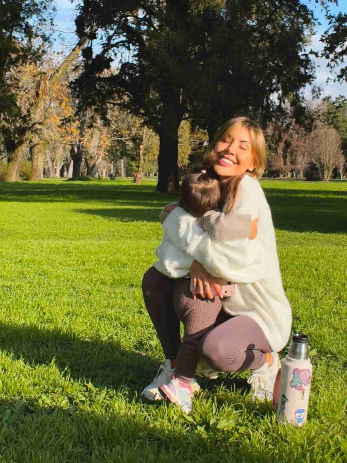 Muri López Benítez abraza a su hija Aurora en un parque de Gualeguay