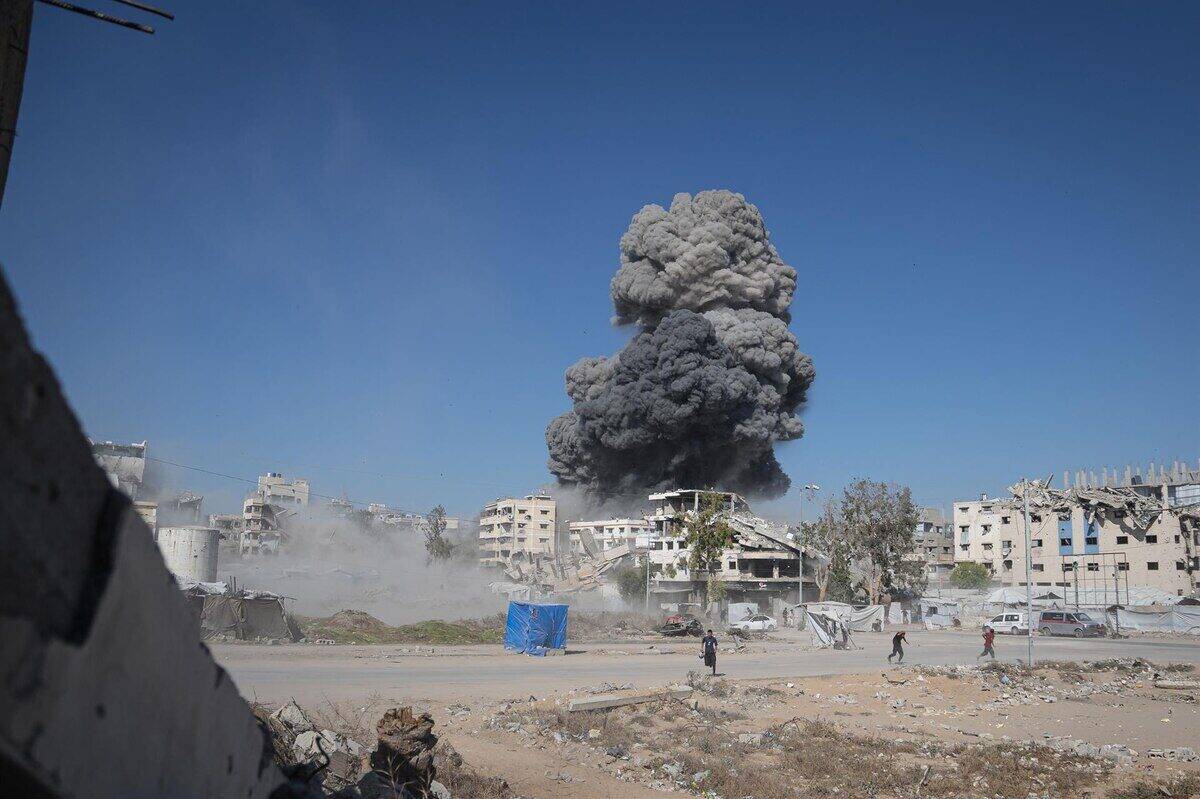 Explosión de humo negro sobre edificios destruidos en una zona de conflicto