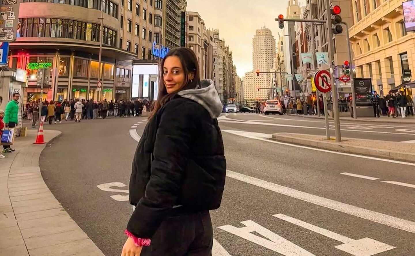 Lucía Distante posando en una calle de Madrid con edificios y gente al fondo
