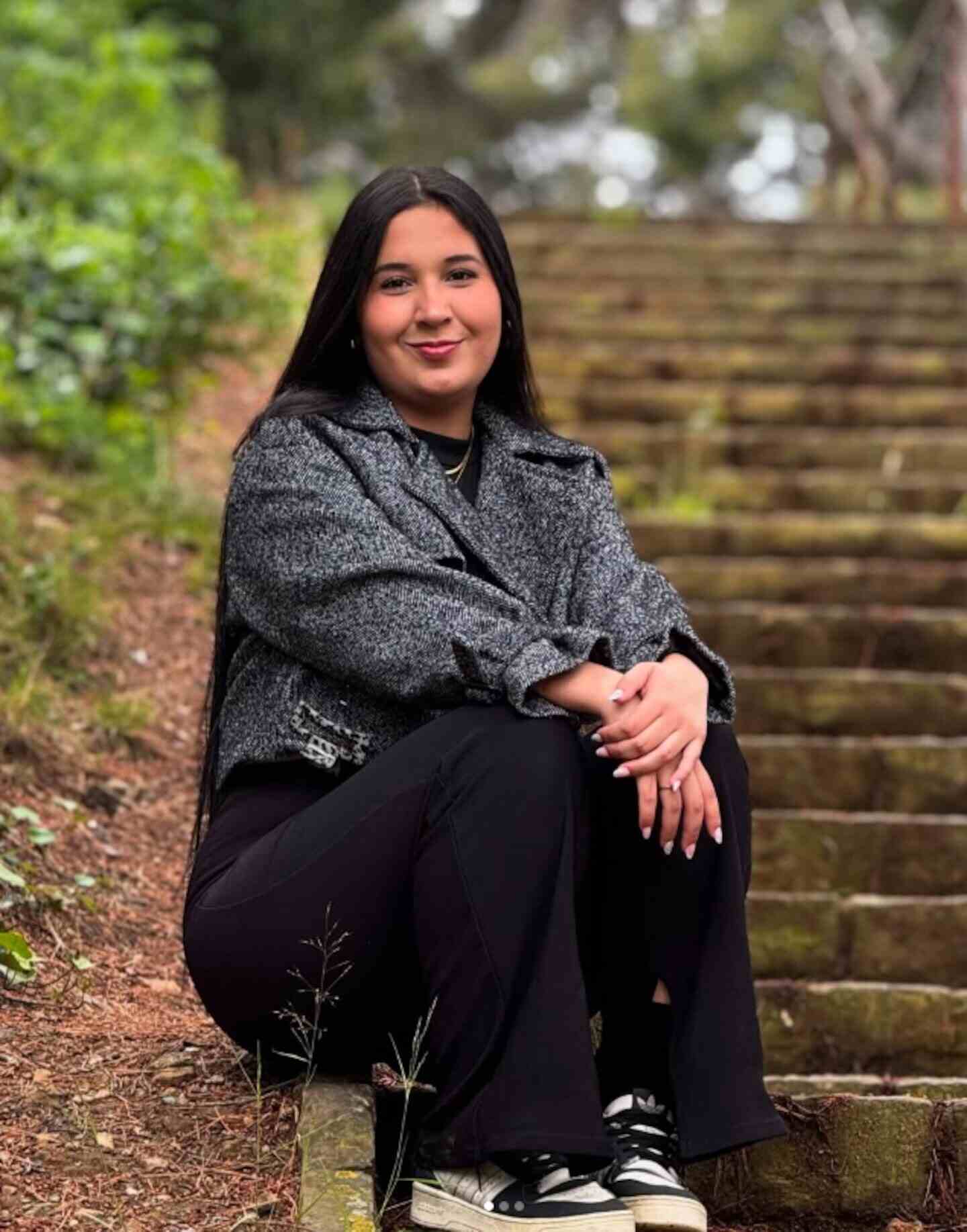 Leslie, una joven colombiana, sentada en escaleras rodeadas de naturaleza
