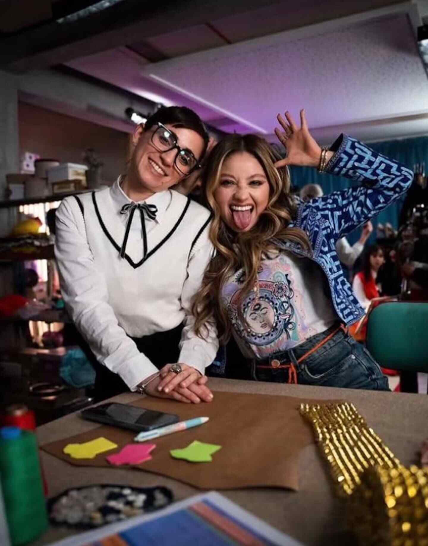 Dos mujeres sonrientes posando juntas en un ambiente de trabajo creativo