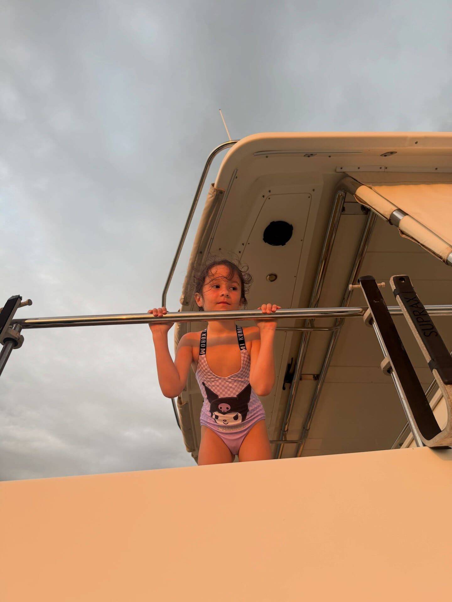 Niña con traje de baño en un yate al atardecer en Costa Rica