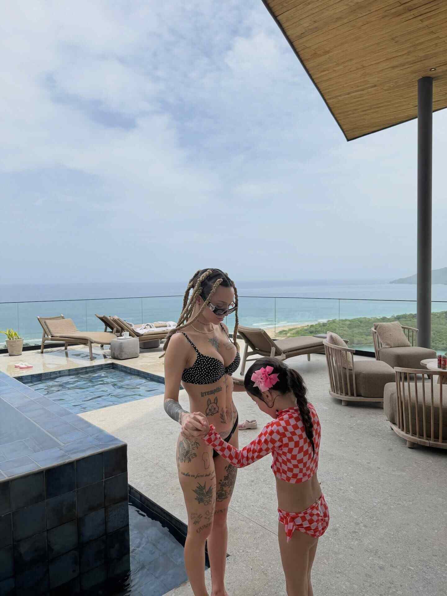 La Joaqui en un yate de lujo en Costa Rica, luciendo un microbikini negro y trenzas africanas junto a su hija