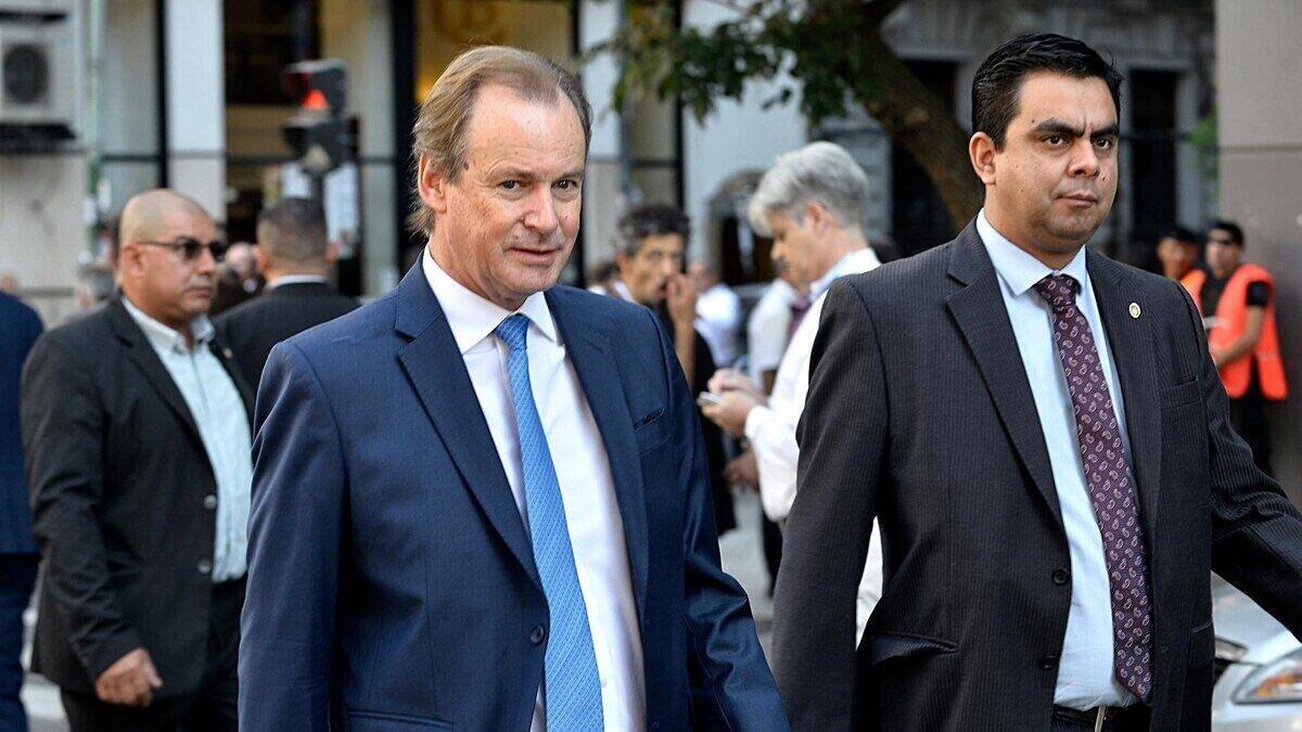 Gustavo Bordet, exgobernador de Entre Ríos, caminando junto a un asesor en un evento público