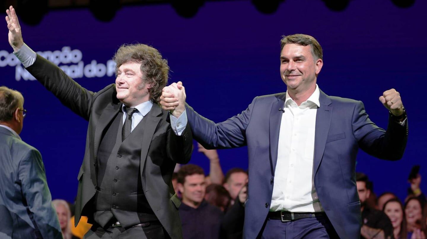 Javier Milei y Pablo Quirno levantan las manos en un evento público
