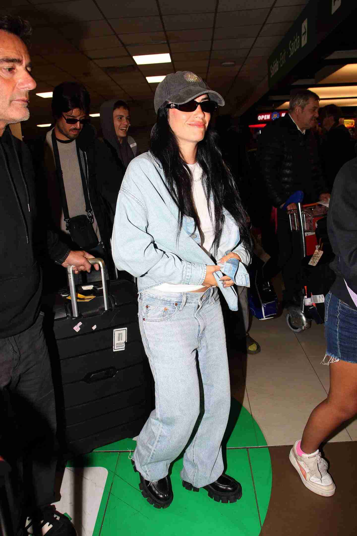 Lali Espósito llegando al aeropuerto con un atuendo casual y una gorra