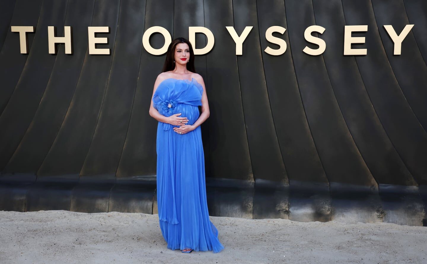 Anne Hathaway posando en la alfombra roja con un vestido azul claro en el estreno de 'The Odyssey'