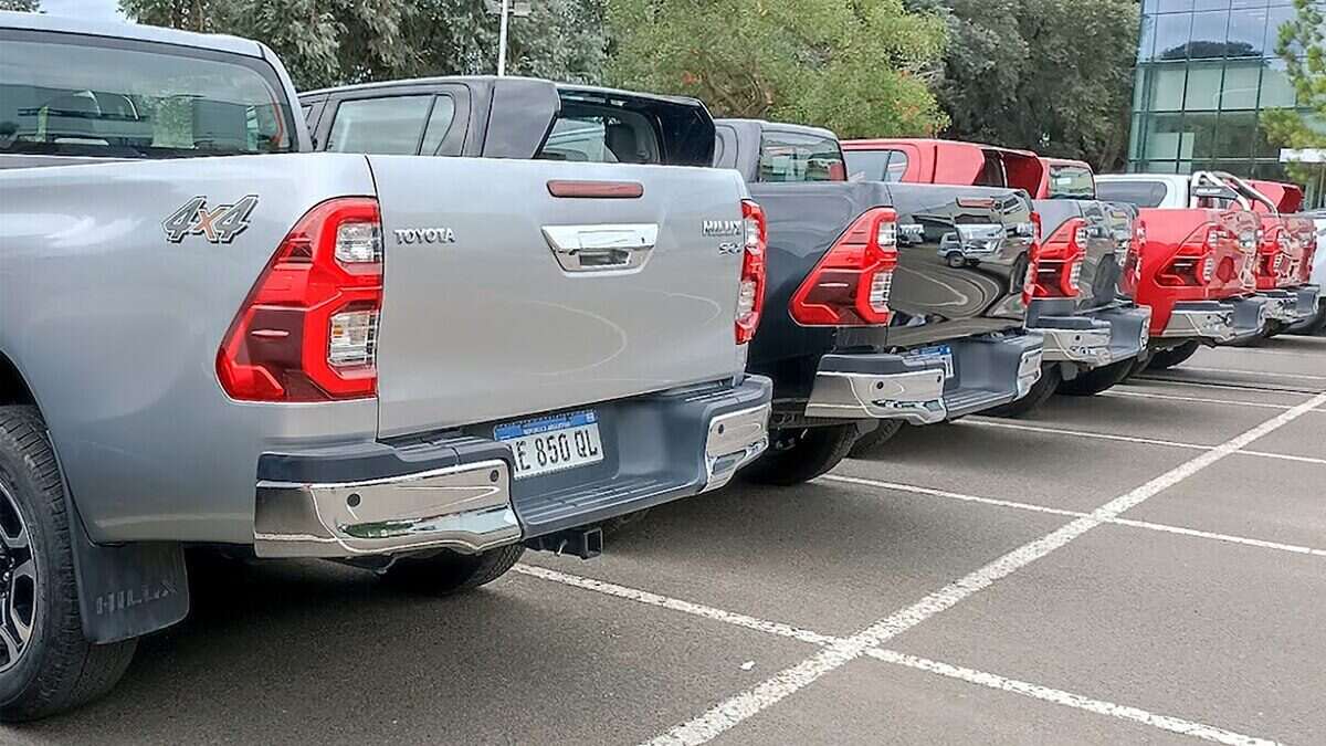 Vista trasera de varias camionetas Toyota y Ford estacionadas en un concesionario en Argentina
