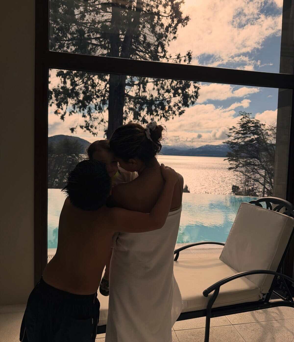 Leandro Paredes abrazando a su hijo junto a una mujer en Bariloche con vista al lago