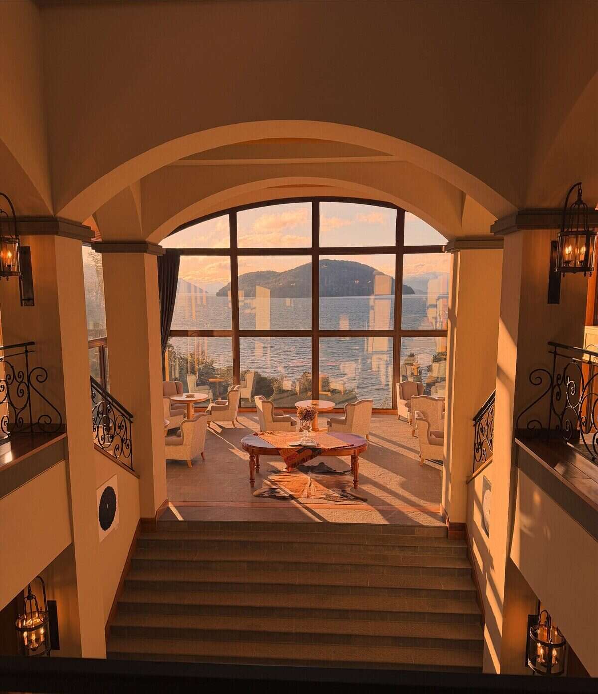 Vista interior de un elegante salón con ventanales que muestran un paisaje montañoso en Bariloche