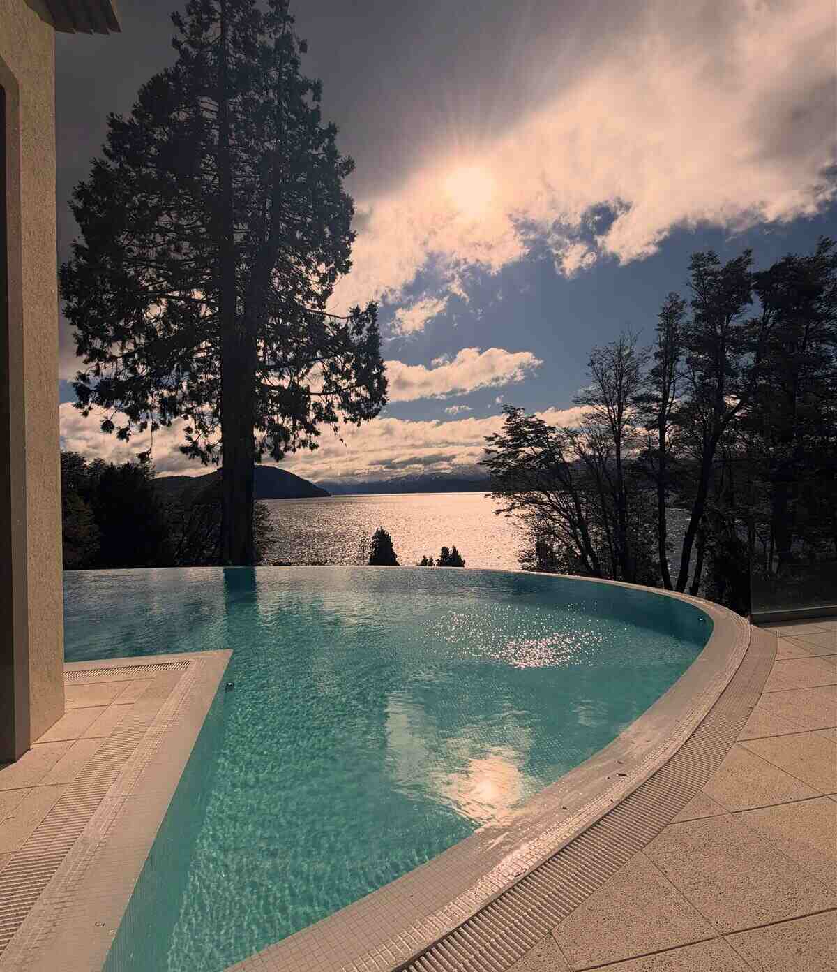 Vista de una piscina infinita con paisaje de Bariloche al fondo