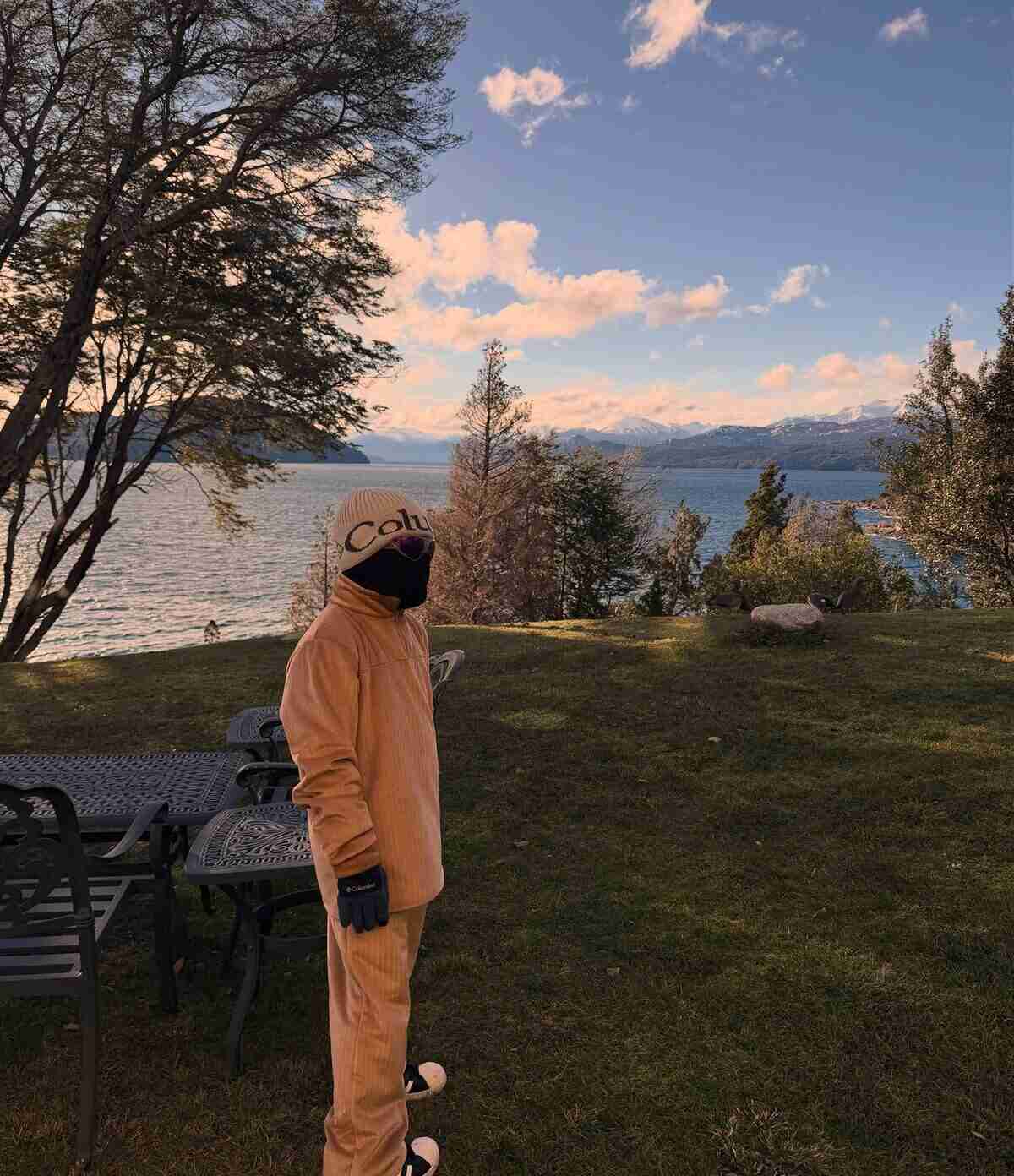 Leandro Paredes de pie en un paisaje natural de Bariloche con vista al lago y montañas