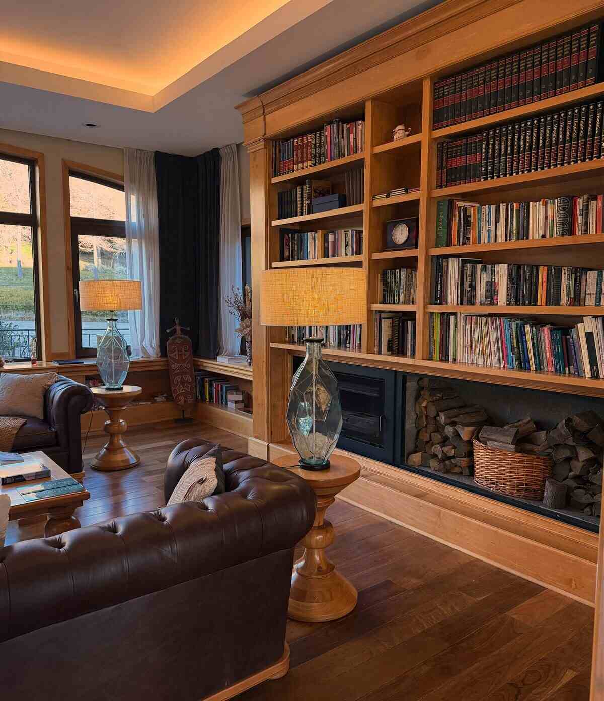 Sala de estar acogedora con estanterías llenas de libros y lámparas de luz cálida en Bariloche