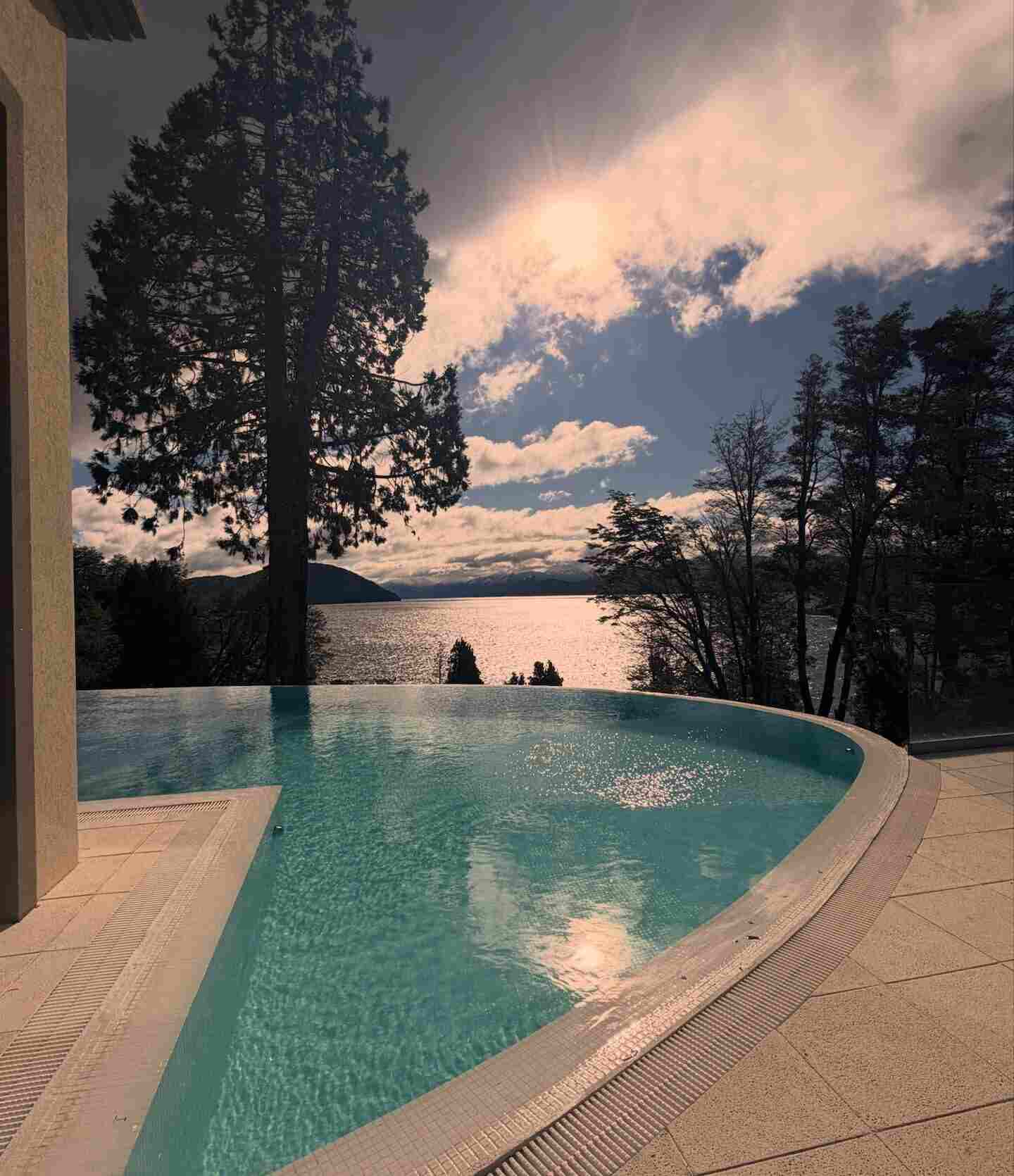 Vista de una piscina infinita con paisaje de Bariloche al fondo