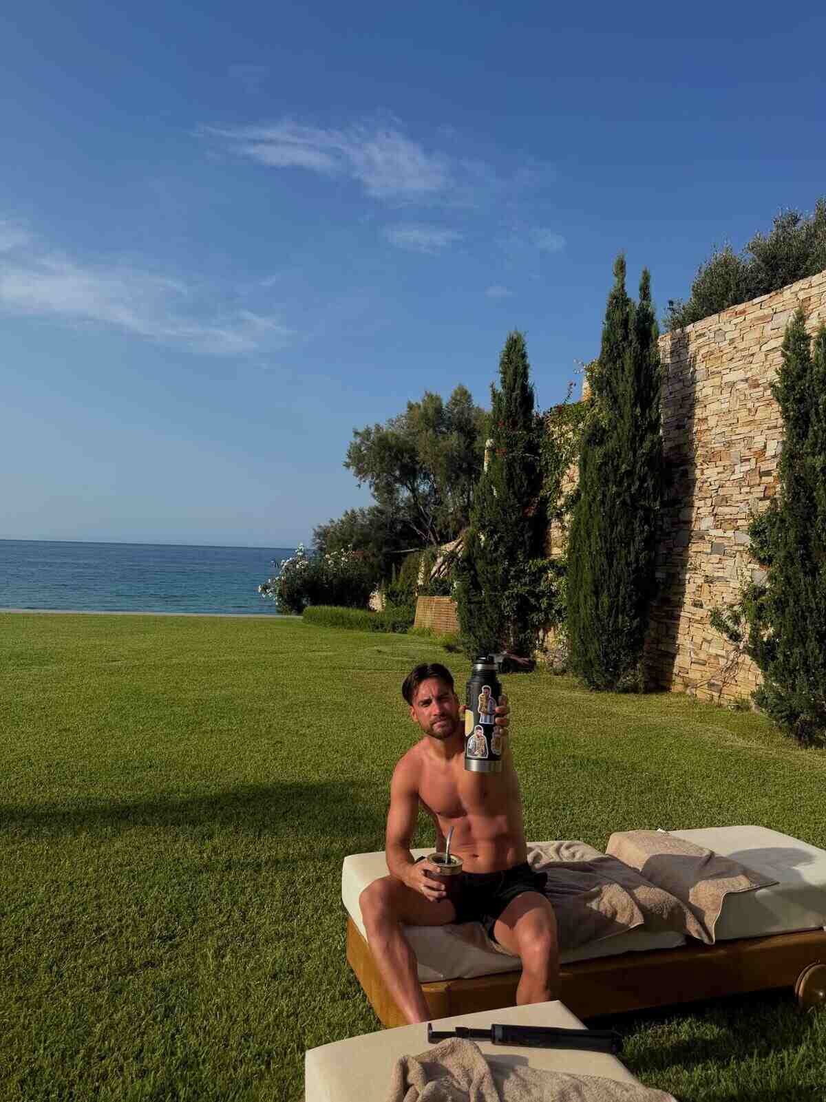 Jugador de la Selección Argentina disfrutando de vacaciones en la playa con una bebida