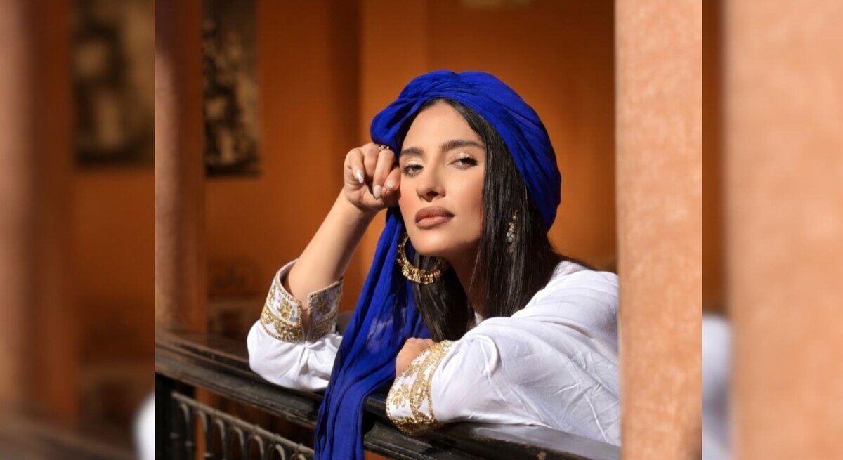 María Aguilar Halak, bailarina argentina con un pañuelo azul, posando en un entorno cultural